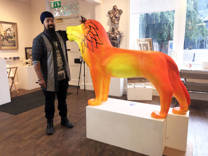 Artist live-painting lion sculpture at Windsor Gallery